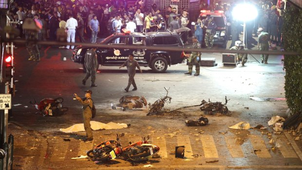 A policeman photographs debris after the August 17, 2015, explosion in central Bangkok.