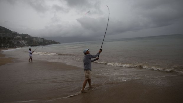 Two men fish as Hurricane Patricia approaches Puerto Vallarta in Mexico.