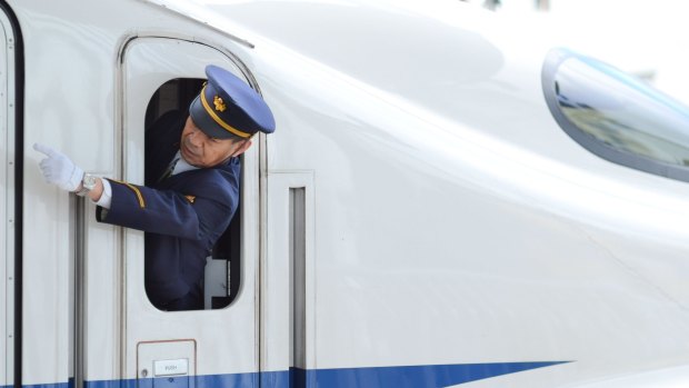 Precision: A guard giving hand signals on a bullet train.