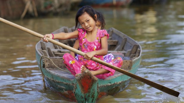 Children in a rowing boat on Tonle Sap Lake in Siem Reap, Cambodia.