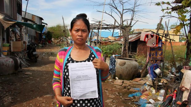 Cambodian surrogate mother Hour Vanny, holding the two-page document she signed with Fertility Solutions, operated by Australian nurse Tammy Davis-Charles. 