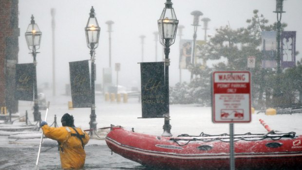 A Boston firefighter wades through flood waters from Boston Harbour on Thursday.