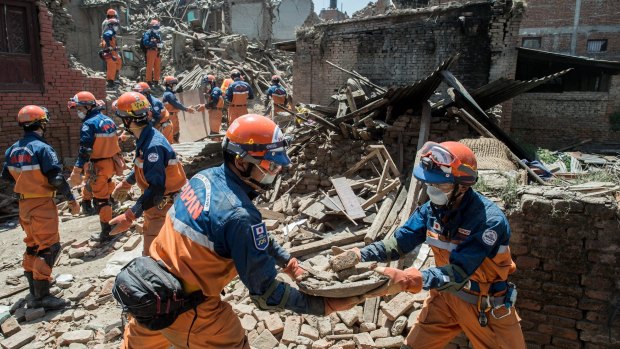 A Japanese disaster relief team remove debris from a collapsed building in Nepal.