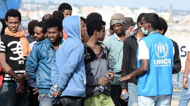 Migrants disembark from the Italian military ship "Sfinge" in Sicily on Thursday.