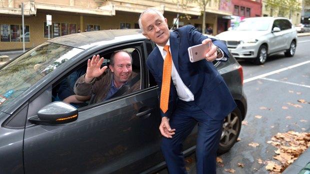 Malcolm Turnbull poses for a selfie with a driver.