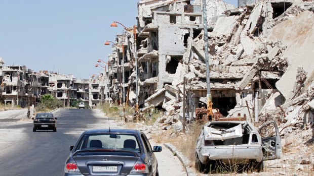 Damaged buildings and rubble line a street in the Syrian city of Homs on Monday.