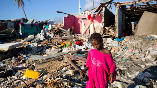 A girl walks through debris where homes once stood after Hurricane Matthew hit Jeremie, Haiti.