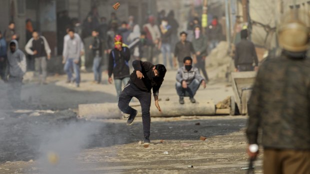 A Kashmiri protester throws stones at Indian paramilitary soldiers during a clash in Srinagar on Monday.
