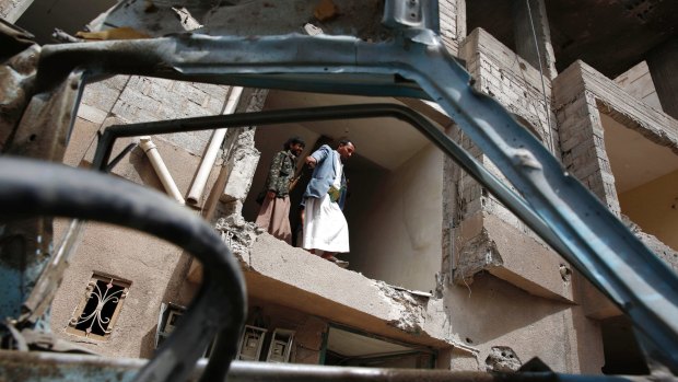 Yemeni people inspect a house damaged by a Saudi air strike in Sanaa, Yemen, last August.