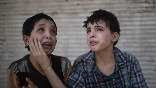 Zeid Ali, 12, left, and Hodayfa Ali, 11, comfort each other after their house was hit and collapsed during fighting between Iraqi forces and Islamic State militants in Mosul, on Saturday.