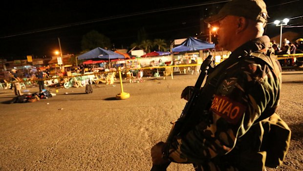 A Philippine soldier keeps watch at the bombing site in Davao, Philippines on Friday.