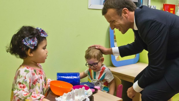 French President Emmanuel Macron visits a kindergarten in Gennevilliers, north of Paris. Critics say gender inequality is embedded in the French language.
