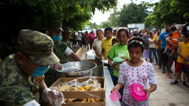 Soldiers serve breakfast to people sheltering at a school after their homes were destroyed or damaged in Thursday's earthquake, in Juchitan, Oaxaca state, Mexico.