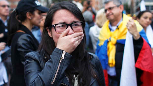 A supporter of the original peace accord cries as she follows on a giant screen the results of the October referendum that defeated it.