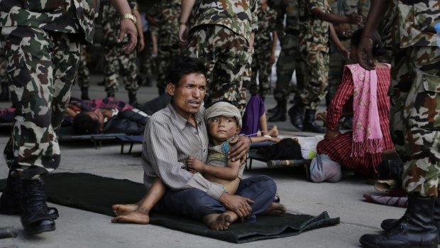 A villager sits with a child on his lap  after being evacuated in the aftermath of April's earthquake.