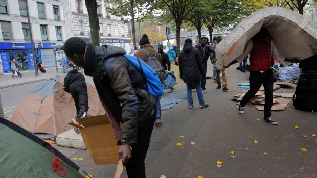 A migrants carries a mattress in a makeshift camp in Paris, on Friday.