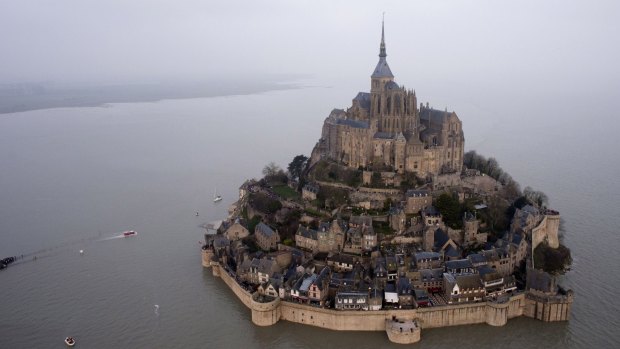 After: a supertide turns France's famed Mont Saint-Michel into an island.