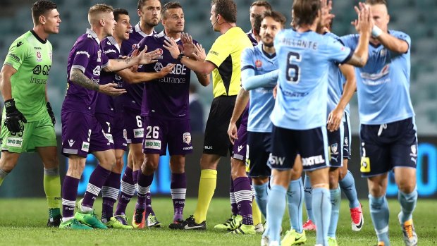 Chaotic scenes: Perth players surround referee Peter Green after a video referee decision went against them.