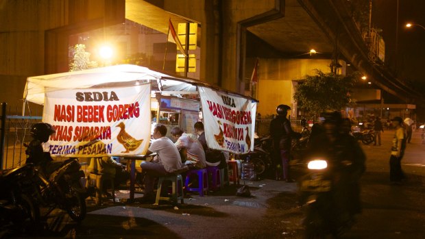 A roadside stand in Jakarta sells duck with stir-fried rice.