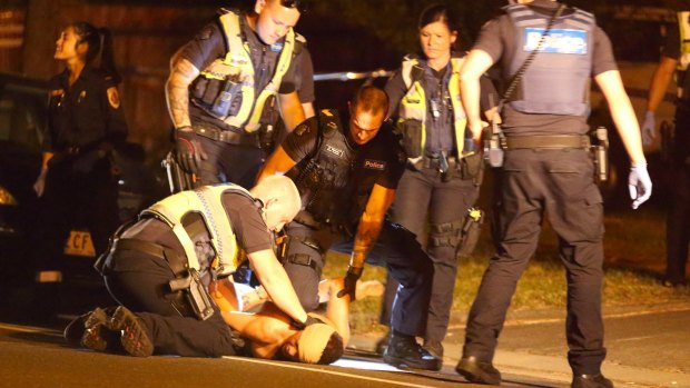 Police restrain an injured man at Springvale on Friday.