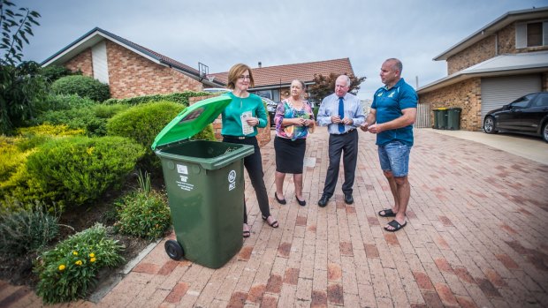 Calwell homeowner Stephen McDougall, right, receiving his green waste bin from a phalanx of ACT Labor politicians on Monday - from left, Meegan Fitzharris, Joy Burch and Mick Gentleman. 