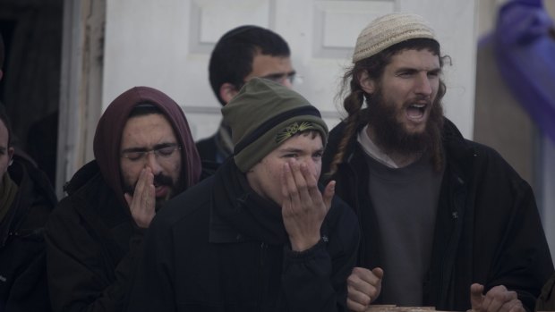 Israeli settlers shout as security forces arrive to evacuate the settlement, built on land owned by Palestinians.