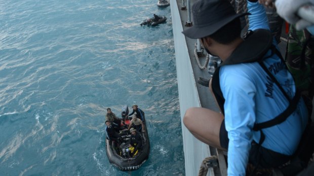 Grim search: Indonesian navy divers prepare operation to lift the tail of the AirAsia plane.