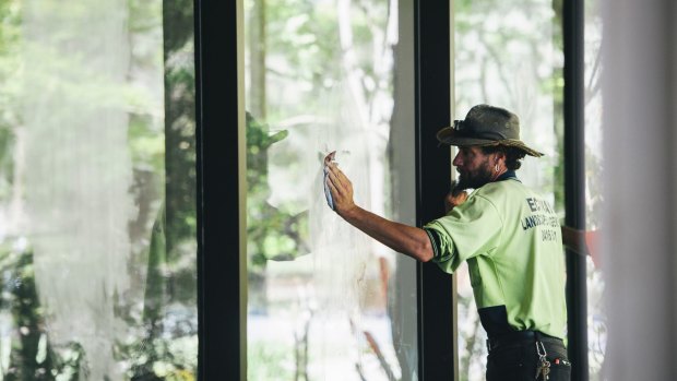 Workers clean Indigenous signs from the building's windows.