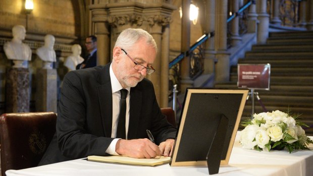 Opposition leader Jeremy Corbyn adds his name to a book of condolence at Manchester Town Hall.