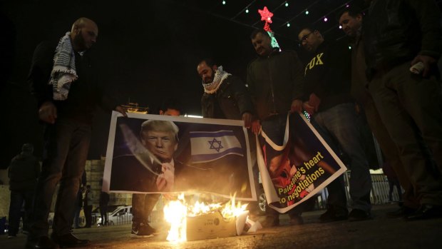 Palestinians burn posters of the Donald Trump during a protest in Bethlehem.