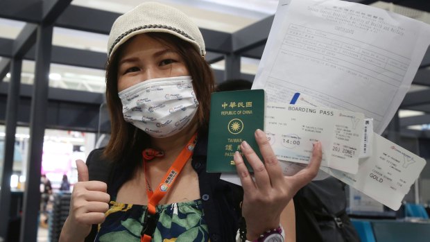Kuo Yitting, one of the first group travelling to Palau, shows her boarding pass and virus test before leaving Taiwan on Thursday.