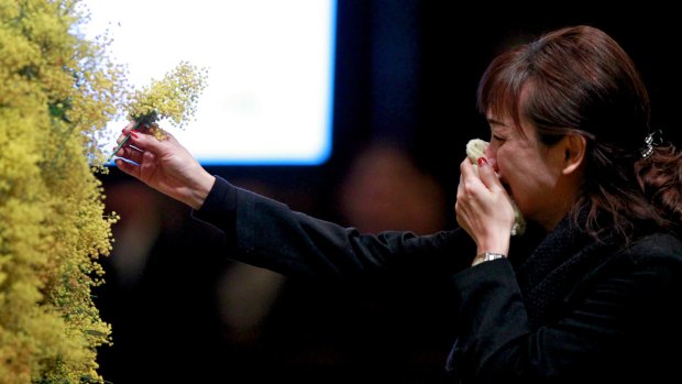 Time for faith: A woman places a sprig of wattle in the cathedral's wreath in honour of the fallen.