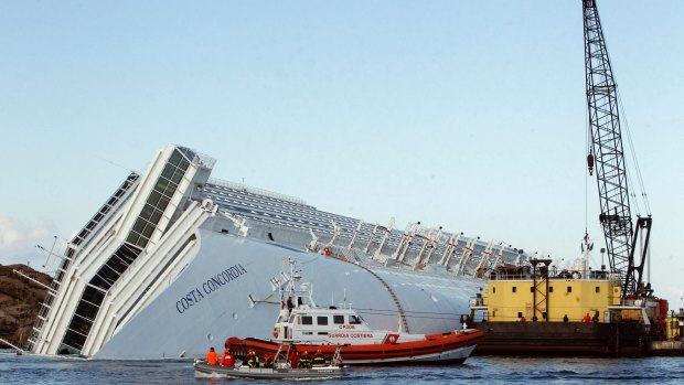 A sea platform carrying a crane approaches the grounded cruise ship Costa Concordia off the Tuscan island of Giglio, Italy  in January 2012. 