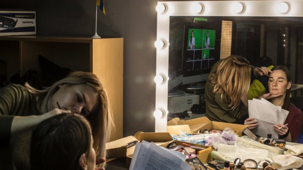 'It is investigative journalism, with a twist': Margo Gontar reviews a script while Kira Zalitok applies makeup before the weekly broadcast of <i>StopFake News</i>.
