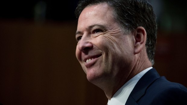 Former FBI Director James Comey smiles during a Senate Intelligence Committee hearing last week.
