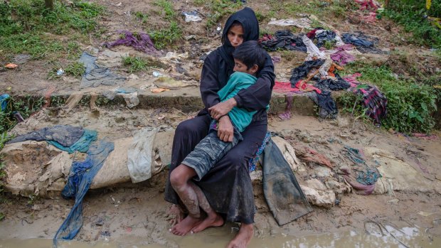 Rohingya woman Mustafa Begum waits for help to transport her sick son Mohammad Riyazullaha to a nearby clinic in Taiy Khali, Bangladesh.