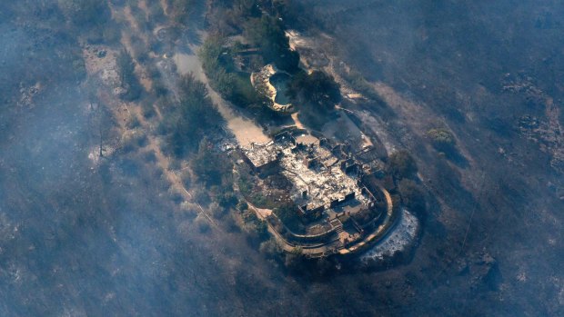 Smoke rises from a home that was destroyed by a fire in the hills east of Napa, California.
