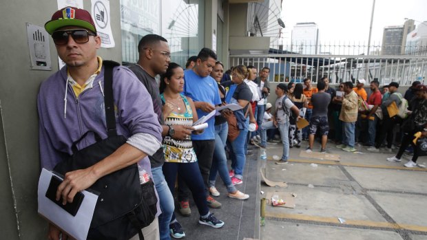 Venezuelan migrants stand in a line to apply for Peruvian residency in Lima, Peru.