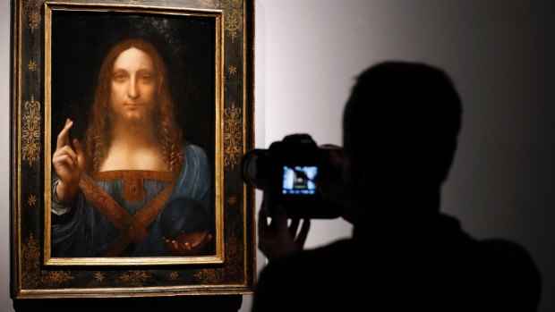 A visitor films Leonardo da Vinci's 'Salvator Mundi' on display at Christie's auction rooms, in London on October 24. 