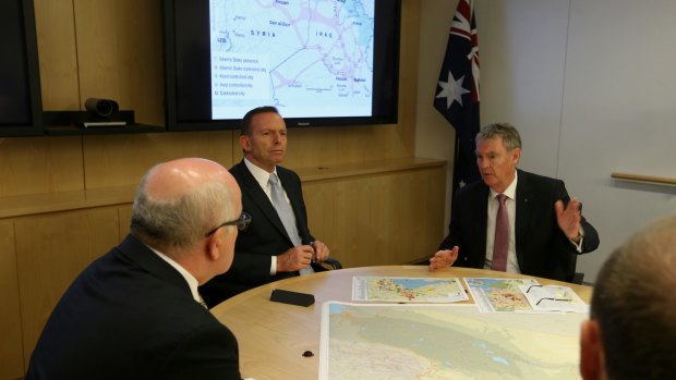 Prime Minister Tony Abbott receives a briefing from ASIO Director-General of Security Duncan Lewis during his visit to the ASIO headquarters in Canberra on Wednesday.