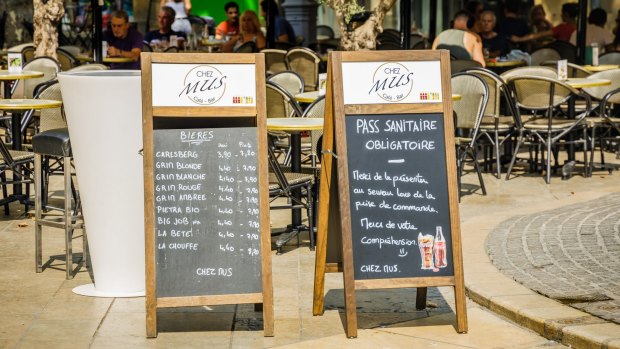 A "health pass required" sign at the entrance of a terrace restaurant in Aix en Provence, France.