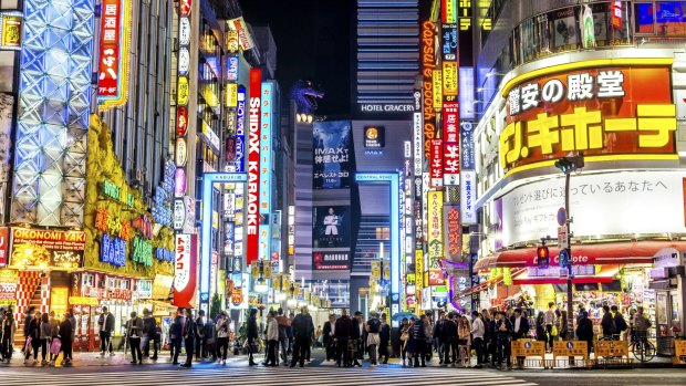Brightly lit neon signs illuminate the popular nightlife Shinjuku district in Tokyo. 