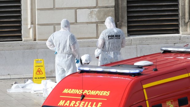 Investigative police officers outside Marseille 's main train station on Sunday after aA man with a knife attacked people at the station.