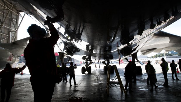 Qantas staff sign the underbelly of the plane.