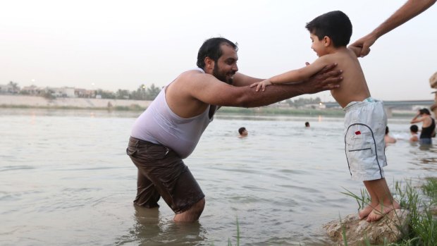 Mustafa Jassim Mohammed, 29, is joined by his son as he practises swimming in the Tigris River in Baghdad, Iraq, earlier this month, in preparation for his Mediterranean Sea voyage en route to Europe. 