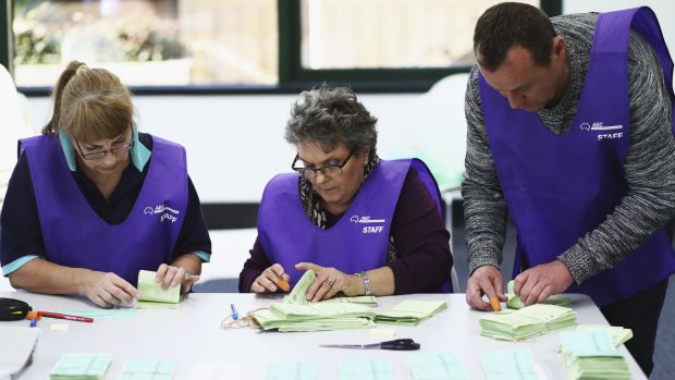 Scrutineers count postal votes at the Gordon counting centre on Tuesday.