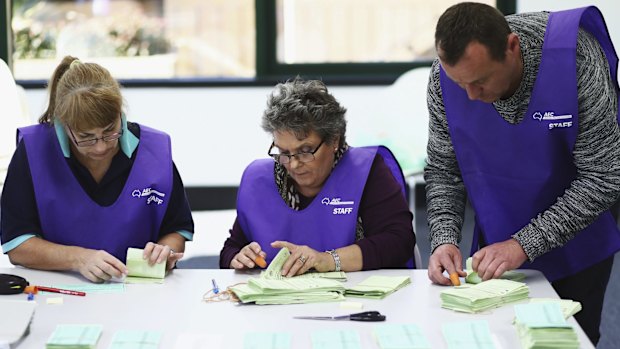 Scrutineers count postal votes at the Gordon counting centre on Tuesday.