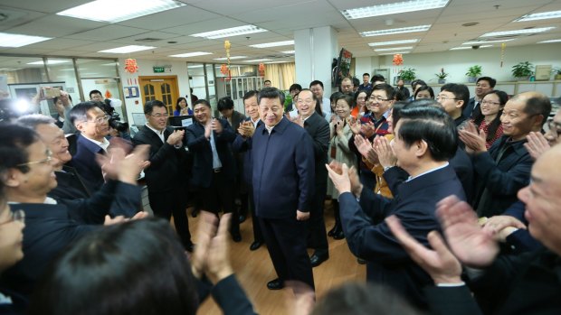 Workers applaud as Chinese President Xi Jinping talks with staff at the People's Daily in February.