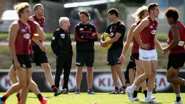 James Hird talks to club doctor Bruce Reid during a training session on Friday.