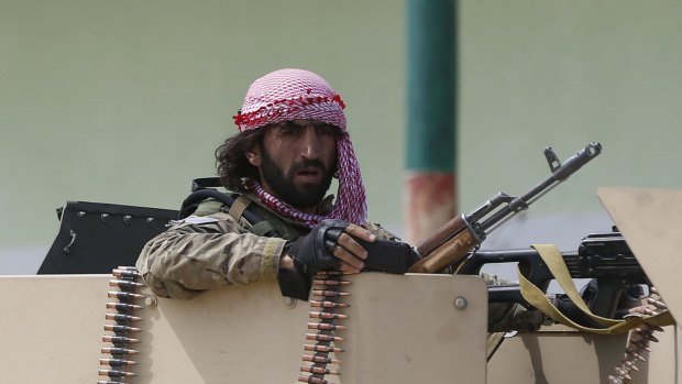 An Afghan soldier keeps watch at Kunduz airport - where last week the Afghan army and police force failed to expel Taliban fighters from the outskirts of the besieged provincial capital.